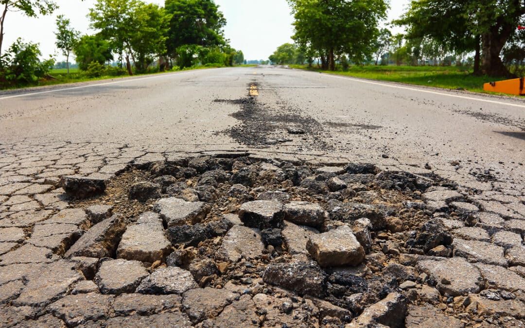 Road With Cracked Pavement And Pot Holes
